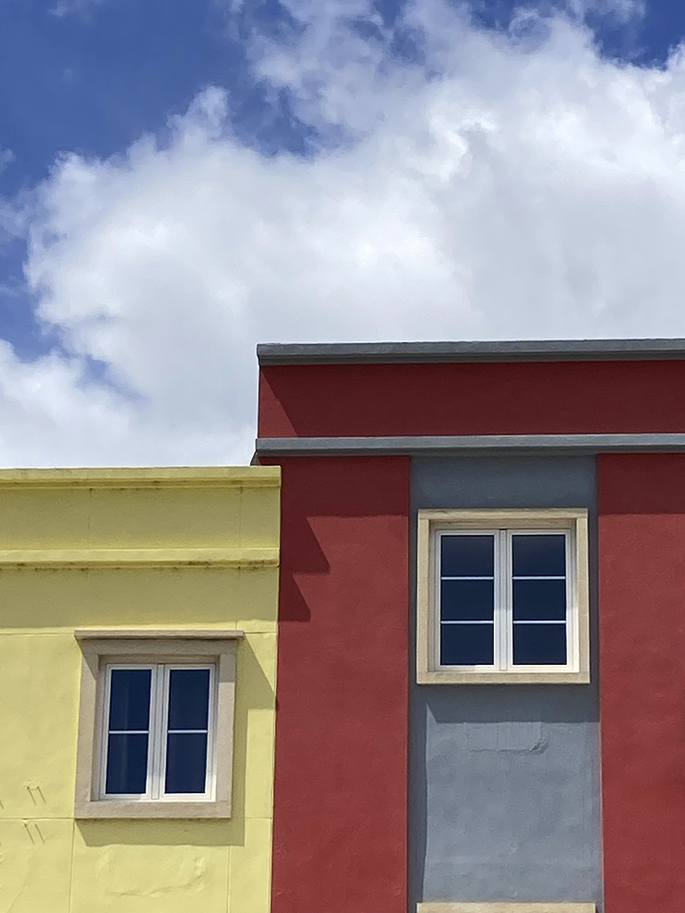 A photo of coloured buildings against the sky in Tavira, Portugal
